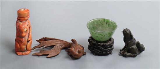 A Chinese stained coral snuff bottle modelled as a shrew, a nephrite bowl, a bronze figure, a fish carving and a stand.